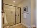 Walk-in shower with a glass door, bench, and tile surround in a renovated bathroom at 1538 Riverwalk Pkwy, Rock Hill, SC 29730