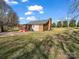 Exterior view featuring a well-maintained backyard, lush green lawn, and a relaxing outdoor area at 2100 Lincolnton Hwy, Cherryville, NC 28021