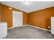 Minimalist bedroom with burnt orange walls and carpet flooring at 2100 Lincolnton Hwy, Cherryville, NC 28021