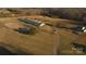 Expansive aerial view of horse farm featuring barn, riding ring, pastures, and outbuildings amid rolling hills and mature trees at 2137 Old Latter Rd, Newton, NC 28658