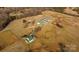 Expansive aerial view of horse farm featuring barn, pastures, and outbuildings amid rolling hills and mature trees at 2137 Old Latter Rd, Newton, NC 28658