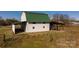 Exterior shot of a large barn featuring a green roof and covered parking, ideal for farm equipment at 2137 Old Latter Rd, Newton, NC 28658