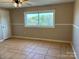 Bedroom with tile floors, chair railing, neutral walls, and a window overlooking the backyard at 2137 Old Latter Rd, Newton, NC 28658