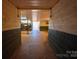 Barn hallway with block walls, showcasing a functional layout and access to different areas within the barn at 2137 Old Latter Rd, Newton, NC 28658