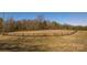 Large riding arena with horses visible in the background and surrounding wooded areas at 2137 Old Latter Rd, Newton, NC 28658