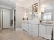 Bright bathroom features dual sinks, marble countertops, neutral paint, and mosaic tile flooring at 2432 Westfield Rd, Charlotte, NC 28207