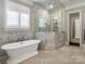 Bright bathroom with a freestanding tub, glass shower and mosaic tile floors at 2432 Westfield Rd, Charlotte, NC 28207