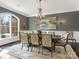 Formal dining room with wainscoting, elegant chandelier, large window and seating for ten at 2432 Westfield Rd, Charlotte, NC 28207