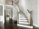 Grand foyer featuring a curved staircase, dark wood floors, and elegant chandelier at 2432 Westfield Rd, Charlotte, NC 28207