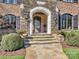 Stone entrance and steps with stylish planters leading to wood front door with glass panes at 2432 Westfield Rd, Charlotte, NC 28207