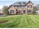 Stately brick home boasts meticulous landscaping, manicured lawn, and classic architectural details at 2432 Westfield Rd, Charlotte, NC 28207