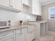 Charming kitchenette with white cabinets, granite countertops, stainless steel microwave and farm sink at 2432 Westfield Rd, Charlotte, NC 28207