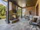 Elegant outdoor patio with a stone fireplace, comfortable seating, and an outdoor grilling area at 2432 Westfield Rd, Charlotte, NC 28207