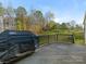 Large wooden back deck with grill, railing, and views of the fenced yard and fall foliage at 2894 Westshore Pl, Denver, NC 28037