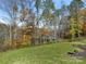 A lush green backyard featuring mature trees with fall foliage and manicured landscaping at 2894 Westshore Pl, Denver, NC 28037