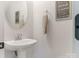 Chic powder room featuring a pedestal sink, round mirror, and elegant wall decor at 2894 Westshore Pl, Denver, NC 28037