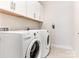 Bright laundry room with white washer and dryer, and overhead cabinets at 2894 Westshore Pl, Denver, NC 28037