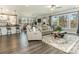 Open-concept living room featuring wood floors, a gray sofa set, large windows, and backyard view at 2894 Westshore Pl, Denver, NC 28037