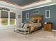 Spacious primary bedroom featuring a tray ceiling, neutral carpet, and decor at 2894 Westshore Pl, Denver, NC 28037
