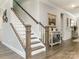 Elegant staircase with white spindles, wooden handrail, and neutral decor at 2894 Westshore Pl, Denver, NC 28037