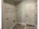 A spacious laundry room with washer and dryer hookups, overhead rack, and white door at 2924 Noritake Trl # 59, Albemarle, NC 28001
