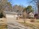 Home featuring a two-car garage and long driveway, surrounded by mature trees and landscaping at 3142 Wimbledon Ln, Rock Hill, SC 29732