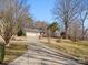 Home featuring a two-car garage and long driveway, surrounded by mature trees and landscaping at 3142 Wimbledon Ln, Rock Hill, SC 29732