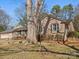 Brick home with black shutters and a cozy bench under a mature tree, enhancing the curb appeal at 3142 Wimbledon Ln, Rock Hill, SC 29732