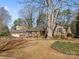 View of a brick home, nestled amidst a sprawling tree, accented with mature landscaping at 3142 Wimbledon Ln, Rock Hill, SC 29732