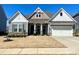 Charming single-Gathering home boasts stone accents, gray siding, and a well-manicured front yard at 3309 Juneberry Pl, Indian Land, SC 29707