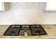 Close-up of stainless steel gas range and decorative tile backsplash at 3309 Juneberry Pl, Indian Land, SC 29707