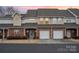 Charming townhome with brick facade, attached garages, and manicured landscaping at dusk at 349 Valley Brook Se Ln, Concord, NC 28025