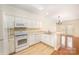 Well-lit kitchen with white cabinets, modern appliances, and a breakfast bar overlooking the living area at 349 Valley Brook Se Ln, Concord, NC 28025