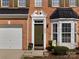 Charming brick home featuring an olive green front door and attached garage at 4022 Carl Parmer Dr, Harrisburg, NC 28075