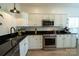 Well-lit kitchen featuring white cabinets, stainless steel appliances, and dark granite countertops at 4022 Carl Parmer Dr, Harrisburg, NC 28075