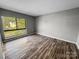 This bedroom features wood-look floors and a large window letting in natural light at 4824 Spring Lake Dr # E, Charlotte, NC 28212