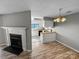 View of fireplace, dining area with modern chandelier, and the kitchen with updated appliances at 4824 Spring Lake Dr # E, Charlotte, NC 28212