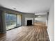 Spacious living room with fireplace, sliding glass door to balcony, and hard surface floors at 4824 Spring Lake Dr # E, Charlotte, NC 28212