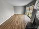 Bright living room with a sliding glass door to a balcony and a fireplace, with hardwood floors at 4824 Spring Lake Dr # E, Charlotte, NC 28212
