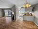 Open-concept living space with fireplace, hardwood floors, and a view of the kitchen with white cabinets at 4824 Spring Lake Dr # E, Charlotte, NC 28212