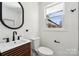 Modern bathroom with stylish vanity, dark hardware, and a window offering natural light and a contemporary design at 4931 Baylor Dr, Charlotte, NC 28210