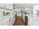 Well-lit kitchen boasts white cabinets, stainless steel appliances, subway tile backsplash, and hardwood flooring at 4931 Baylor Dr, Charlotte, NC 28210