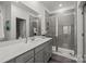 Modern bathroom features a walk-in shower, grey vanity, white countertop and a large mirror at 5021 Cherry Gum Ct, Matthews, NC 28105