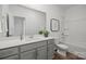 Bright bathroom featuring a combo tub and shower, grey vanity, and a large mirror at 5021 Cherry Gum Ct, Matthews, NC 28105