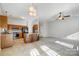 Open-concept living room adjacent to kitchen with tiled floors and modern lighting fixtures at 6038 Burnt Mill Run, Matthews, NC 28104