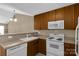 Eat-in kitchen features wood cabinets, white appliances, and neutral countertops at 605 Gable Dr, Rock Hill, SC 29732