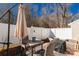 Inviting outdoor patio featuring a patio set with a sun umbrella and a lovely white fence and trees at 605 Gable Dr, Rock Hill, SC 29732