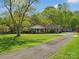 Well maintained single story brick ranch home with long paved driveway and lush green lawn at 6349 Lebanon Rd, Mint Hill, NC 28227