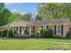 Lovely one-story brick house with black shutters and a cozy covered front porch with rocking chairs at 6349 Lebanon Rd, Mint Hill, NC 28227