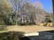 Exterior view features a wide backyard with some sparse grass and trees around the perimeter at 6827 Neuhoff Ln, Charlotte, NC 28269
